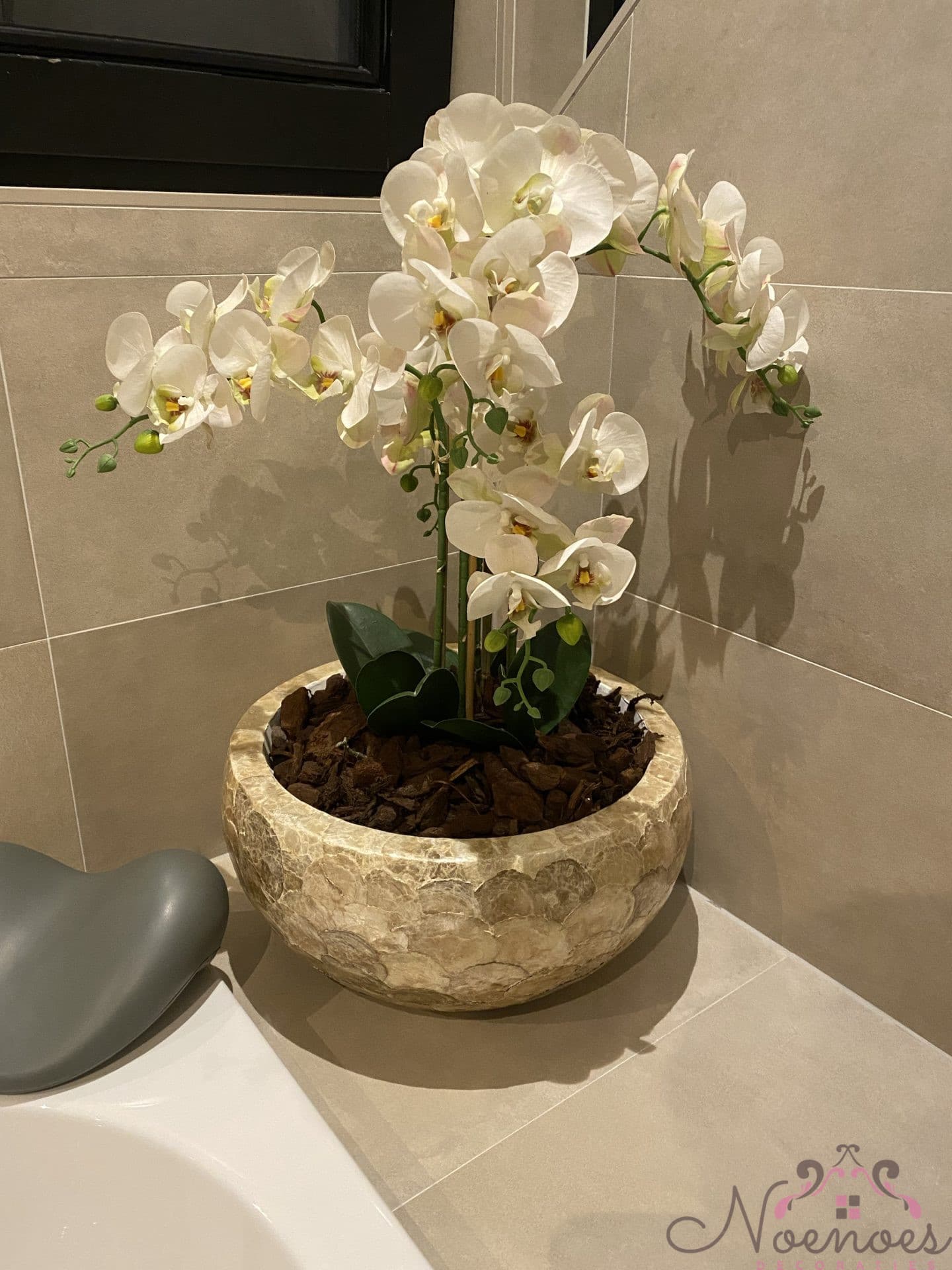 Gouden capiz schelpenvaas opgemaakt met witte orchideeën