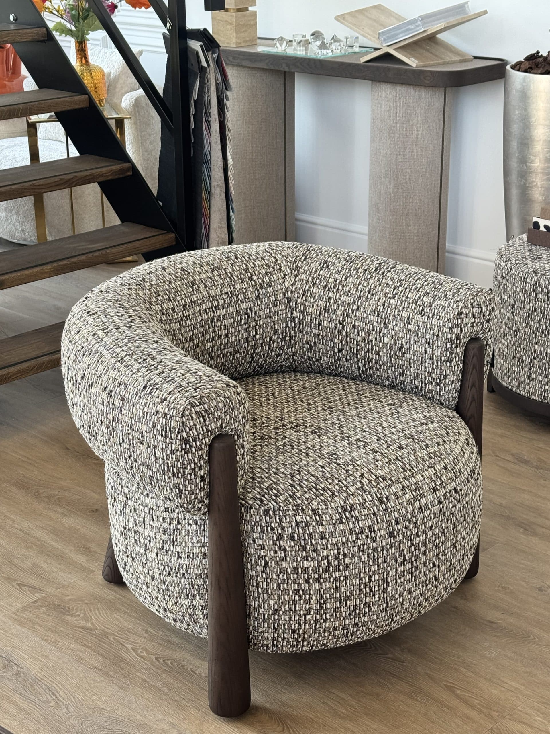 Fauteuil met ronde omsluitende zitting in cappuccinokleurige bouclé stof op donkere houten poten