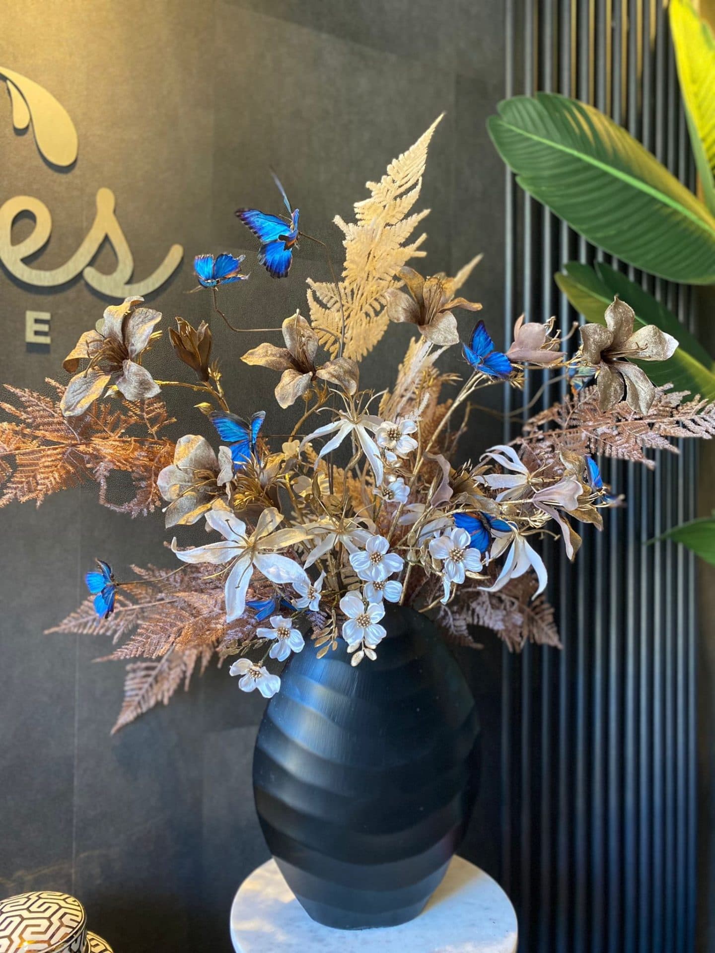 Ribbelvaas opgemaakt met zijdebloemen en blauwe vlinders